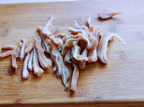 将焯水的猪耳朵切丝。