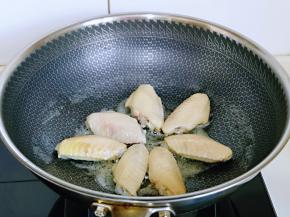 起油锅，把焯水的鸡翅摆放锅中，煎至两面微黄。