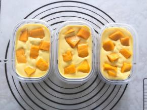 将慕斯糊倒入刚刚做好的盒子中，表面撒上芒果颗粒，放入冰箱冷藏4小时以上