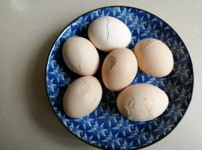 鸡蛋捞起来，用小汤匙将蛋壳轻轻敲出裂纹