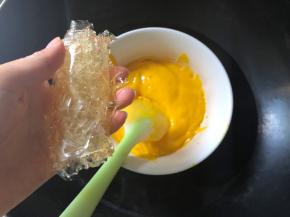 将泡软的吉利丁片挤去多余水份，放入芒果酸奶中，隔热水搅拌至融化