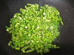 锅里热油放入盐、糖、芦笋粒炒均匀