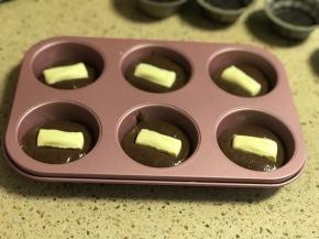 倒入部分巧克力蛋糕液，摆上一块白巧克力。