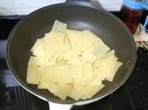 锅里热油放入烤冷面煎炒