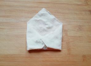 把春卷皮左右两个角向春卷皮中间折叠。