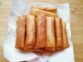 盘子里铺上厨房用纸，放上炸好的春卷。