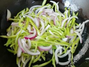 锅底留余油，下入青椒和洋葱丝翻炒均匀。