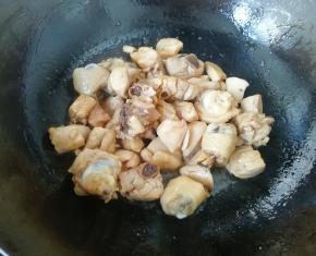 炒锅内倒入适量的菜籽油烧热，先下入糖小火炒出糖色，然后下入鸡腿肉翻炒均匀。