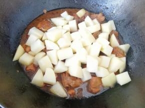 鸡腿肉炖半个小时之后下入土豆块翻炒均匀。