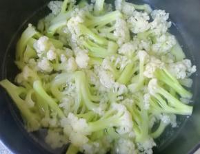 锅内放水烧开，下入有机菜花焯水至断生，捞出过凉水，沥干水分备用。