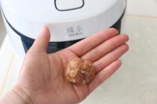手上抹一些水，取一勺肉馅左右摔打几下，揉成肉丸。