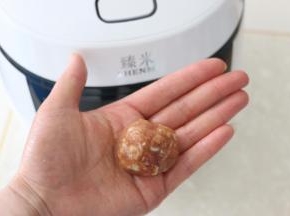 手上抹一些水，取一勺肉馅左右摔打几下，揉成肉丸。