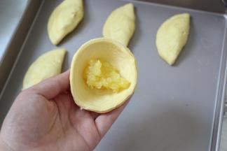 蛋挞皮提前室温软化，每个里面放一小勺菠萝馅。