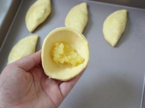 蛋挞皮提前室温软化，每个里面放一小勺菠萝馅。
