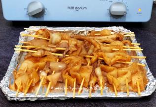 先把烤盘用锡纸包好，包的目的是烤好之后烤盘不会弄脏，也不需要清洗，把腌制好的用鱿鱼用竹签串起来，依次把所有的鱿鱼串好