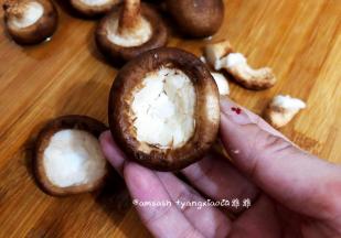 蘑菇清洗干净后，用剪刀把蘑菇蒂剪去，剪的时候可以稍微剪深一点点，这样子装酱料的时候好装一些