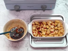 把土豆平铺好装进烤盘中，腌制的时候有剩的酱汁备用着