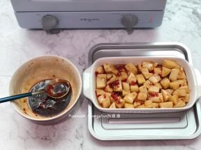 把土豆平铺好装进烤盘中，腌制的时候有剩的酱汁备用着
