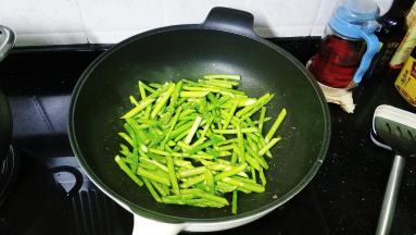 锅里热油放入芦笋段炒至七成熟