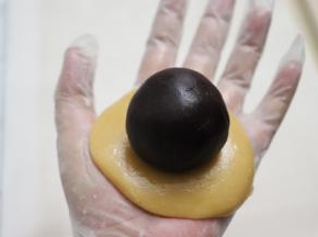 .取出一块面团，压扁，放上准备好的馅料球。
