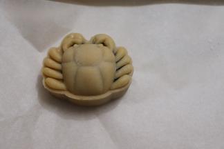 反扣在垫了油纸的烤盘上大力且速度的按压2-3下，抬起模具，一只小螃蟹就可以了。