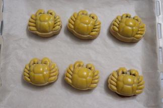 在小螃蟹表面轻轻的、迅速的刷上一层全蛋液，蛋液一定不要过多，用毛尖处反复刷2次即可。