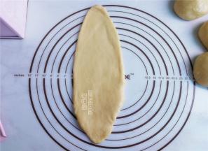 把面团擀成长舌状，卷回来，依次进行，放入吐司盒中加盖。