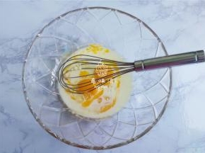 在蛋黄料理盆中倒入牛奶和玉米油充分的搅拌融合。