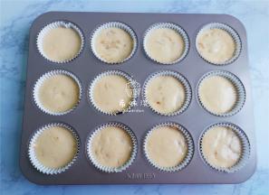 取一个烤盘铺入蛋糕模，把蛋糕糊装入裱花带中，挤入蛋糕中八分满。