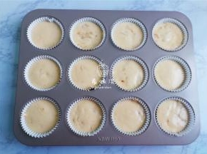 取一个烤盘铺入蛋糕模，把蛋糕糊装入裱花带中，挤入蛋糕中八分满。