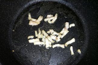 锅中倒入玉米油开小火，油温七成热开大火放入猪肉丁炒熟