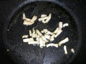锅中倒入玉米油开小火，油温七成热开大火放入猪肉丁炒熟