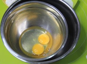 两只55-60克左右的常温蛋，洗净用厨房纸巾擦干，打入底部略宽一点的无水干净盆中，底下水浴，如图另外准备一个盆，放入半盆50度左右热水，进行水浴。让蛋液打发的时候保持温热状态