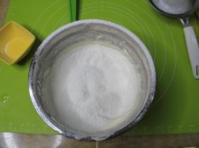 均匀倒入提前过筛好的低粉，千万不要把粉倒在一个地方，太重的话会把面糊压消泡。一定要均匀分散在整个蛋糊表面。