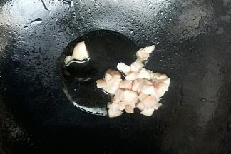 锅中倒入玉米油开小火，油温七成热开大火放入猪肉丁炒熟