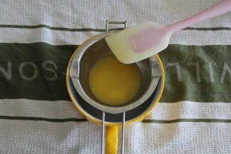 2、主料中的黄油直接装入融化碗里，架在一碗温热的水上，静置一会，等黄油差不多融化，用刮刀搅拌均匀，保温备用。