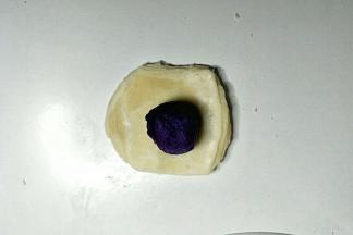 取一个酥皮按扁，包入紫薯馅