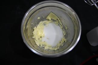 加入糖粉（如果没有糖粉，可以把细砂糖用料理机打一下，如果料理机都没有，可以细砂糖放保鲜袋里用擀面杖来回擀细，不过还是建议用糖粉）用硅胶刮刀稍微混合一下（防止糖粉飞溅）。