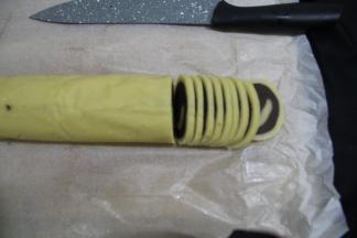 预热烤箱上下200度。取出冻硬的卷。横片切0.3CM的薄片，均匀薄片即可。