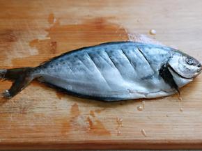 首先将雪花鲳鱼去鳃，取出内脏，洗干净，鱼身体两面用刀划几道，不要太深，放入盘中。