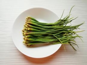 从蒜苔上摘取蒜苔尖。