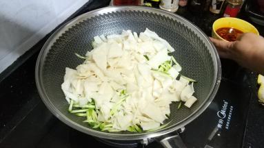 将凉皮、青瓜丝倒入锅里