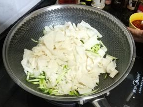 将凉皮、青瓜丝倒入锅里