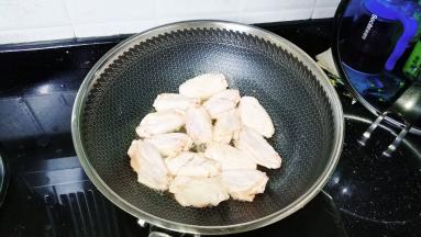 鸡中翅在表面切两刀方便入味，洗干净沥干水分后放入锅里煎至金黄