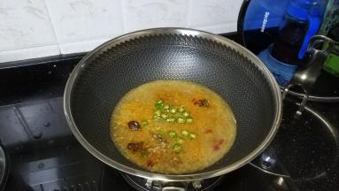 将蒜蓉、线椒、草果、八角、桂叶、糖、盐放入锅里煸炒出香气