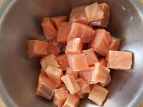 三文鱼切成小块，放入碗中。
