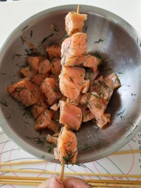 用竹签将腌制好的三文鱼穿成串
