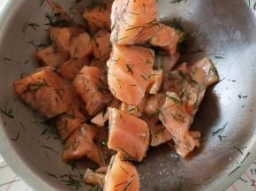 用竹签将腌制好的三文鱼穿成串
