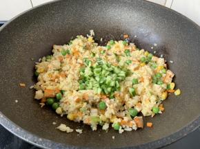 放入米饭，翻炒均匀，不停的翻炒，翻炒至米饭粒干爽，然后放入黄瓜丁，再次翻炒均匀。