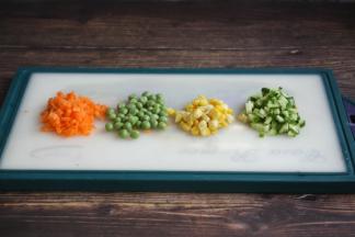 将胡萝卜、黄瓜切丁，豌豆清洗干净、熟玉米掰成粒备用。